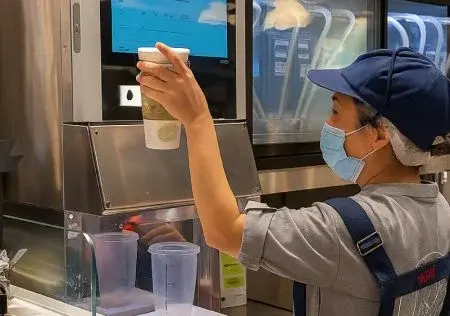 Tela mostrando um funcionário da loja de bebidas operando a estação de barista inteligente.
